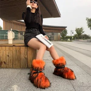 Y2K punk style orange faux fur platform snow boots with rivet straps shown in street style