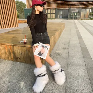 White faux fur platform snow boots featuring punk-style studded straps in a lifestyle setting