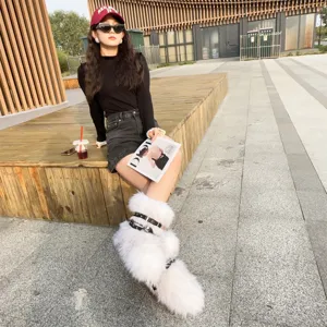 White Y2K faux fur boots with punk buckles shown in an outdoor street fashion setting