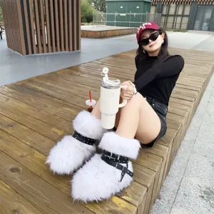Detailed view of white faux fur Y2K platform boots with black studded straps on model