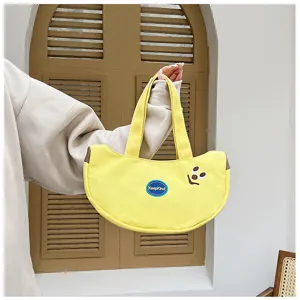 Detailansicht der süßen bananenförmigen Canvas-Handtasche mit Stickerei-Smiley