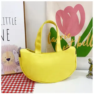Detailansicht einer leuchtend gelben halbmondförmigen Canvas-Handtasche in Geschenkoptik