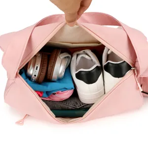 Grand sac de voyage rose montrant l'espace interne avec chaussures et écouteurs