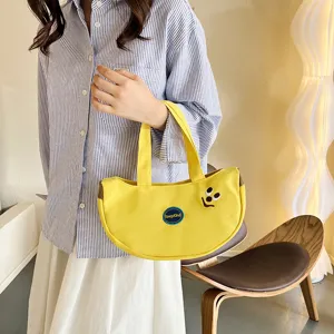 Süße gelbe bananenförmige Segeltuchhandtasche mit Cartoon-Stickerei und Lächeln