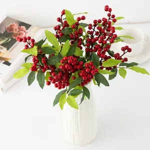 Vue détaillée des branches de baies rouges artificielles, idéales pour la décoration de Noël.