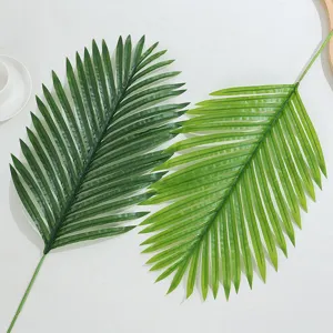 Artificial palm leaf detail view, green plastic plant prop for home decor and floral arrangement.