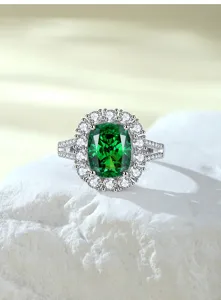Close-up detail van de kussengeslepen groene edelsteenring met sprankelende diamanten halo.