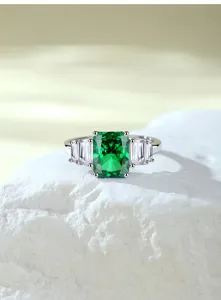 Detail van een smaragds geslepen groen steen ring in zilver met prachtige schitterende stenen.