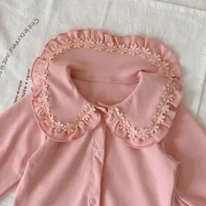 Joli body à manches longues pour bébé fille avec un col à volants et fleurs roses douces.