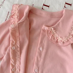 Combinaison rose manches longues pour bébé fille avec col en dentelle et boutons pression.