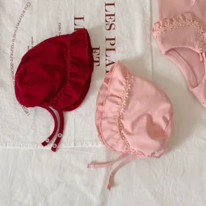 Joli ensemble bonnet et barboteuse bébé avec délicate dentelle florale et coton doux.