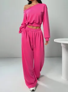 Trendy hot pink off-shoulder crop sweatshirt and loose sweatpants casual tracksuit set.