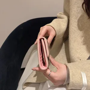 Elegant long women's tri-fold wallet with multiple card slots and secure snap closure, portable storage.