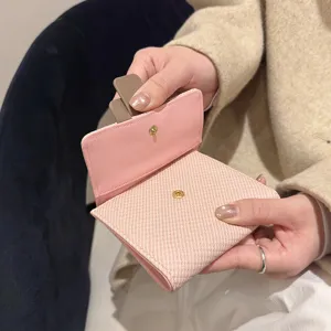 Pink leather tri-fold wallet for women with snap button and card slots compact design.