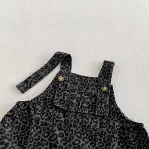 Detail shot of infant baby leopard print overalls romper front pocket and button straps.