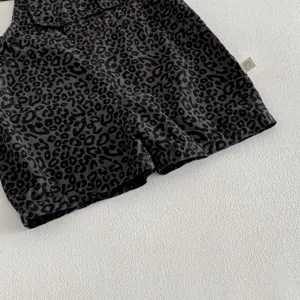 Infant leopard print overall shorts detail view, featuring front pocket and size tag.