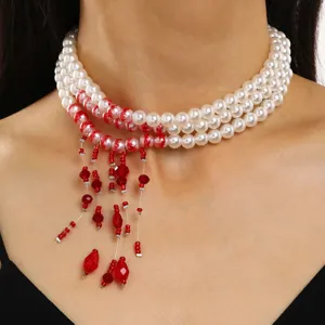 Close-up of elegant multi-layer pearl necklace with red crystal tassel details
