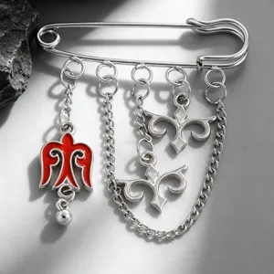Detailed close-up of a Kazakh style silver brooch with red enamel charms and chains
