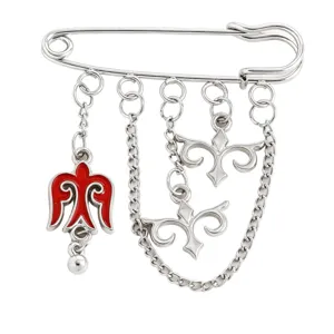Detailed view of a Kazakh style brooch featuring red enamel charms and silver chains
