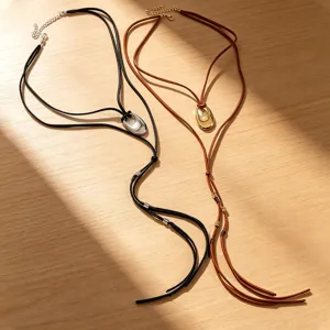 Detail von Retro-Kordelketten mit ovalen Gold- und Silberanhängern im Boho-Stil.