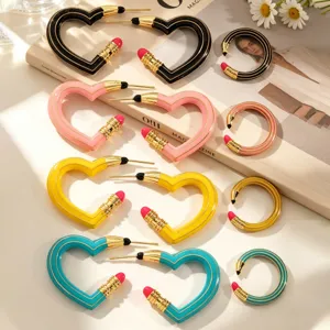 Detailansicht farbenfroher herz- und ringförmiger Bleistift-Ohrringe mit Emaille-Finish