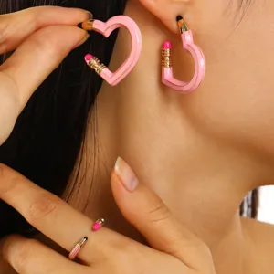 Detailansicht der rosa herzförmigen Bleistift-Ohrringe und des Rings