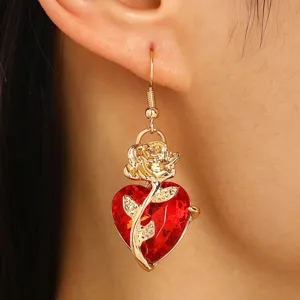 Gros plan détaillé d'une boucle d'oreille gothique cœur rouge avec détail rose dorée