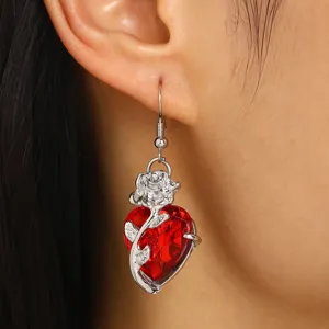 Gros plan d'une boucle d'oreille gothique en cristal de cœur rouge et rose argent