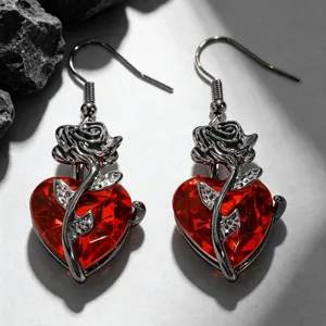 Gros plan de boucles d'oreilles gothiques cœur rouge avec motif de rose argentée