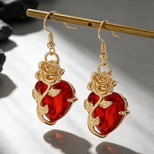 Gros plan détaillé de boucles d'oreilles gothiques avec rose entrelacée et cœur rouge