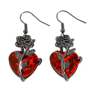 Vue détaillée de boucles d'oreilles cœur rouge gothique avec motif de rose noire.