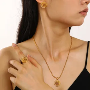 Detail of retro gold jewelry set featuring hollow engraved disc necklace and ring