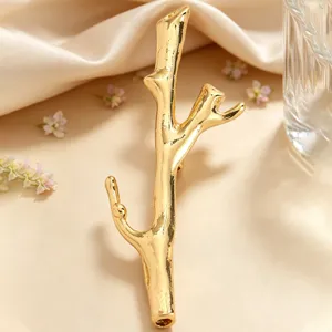 Detailed view of the elegant golden branch brooch with DIY flower-insert feature