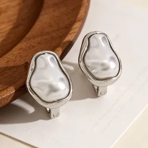 Dettaglio di orecchini con perle barocche ed eleganti montature in metallo argento