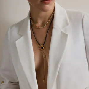 Detailansicht einer goldfarbenen Edelstahl-Halskette mit Herzanhänger an einem Model