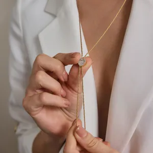 Elegante Detailansicht einer Herz-Lariat-Halskette mit Strass zu einem weißen Blazer