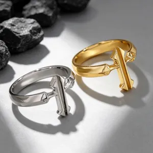 Detailed view of gold and silver cross rings featuring a unique sword-inspired design.