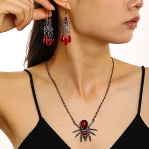 Gros plan sur l'ensemble de bijoux araignée Halloween avec gemmes rouges en goutte