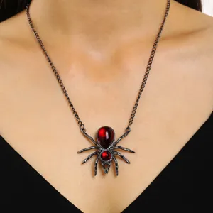 Vue détaillée d'un collier araignée gothique avec pierres rouges pour fête Halloween
