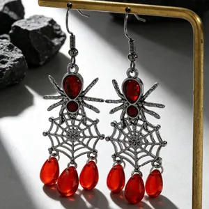 Gros plan de boucles d'oreilles toile d'araignée gothique avec pierres rouges pour Halloween