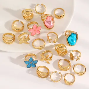 Detailed shot of vintage gold rings with baroque pearls and colorful flower designs
