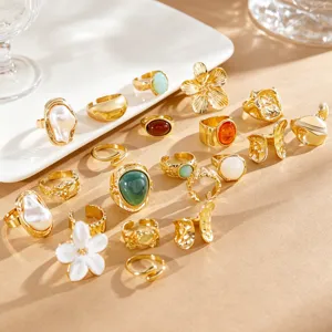 Detailed view of a vintage gold ring set with Baroque pearls and white floral designs