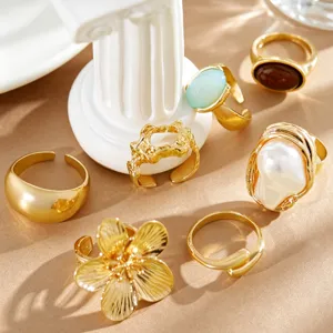 Close-up of vintage gold rings with baroque pearl, flower motifs and molten metal textures