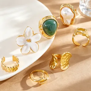Detailed view of a vintage gold ring set featuring Baroque pearl and white flower