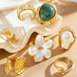 Detailed close-up shot of vintage gold-toned ring set with baroque pearl and flower motifs