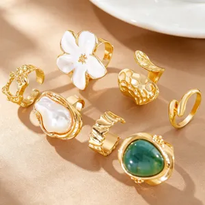 Detailed view of seven-piece vintage gold ring set with baroque pearl and white flower