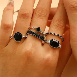 Close-up detail of vintage silver rings set with faceted black gemstones on hand