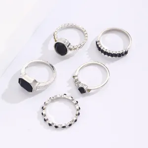 Detail view of vintage silver ring set featuring dark blue stones and textured metal.