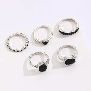 Vintage silver-tone ring set featuring five unique bands with black stone accents