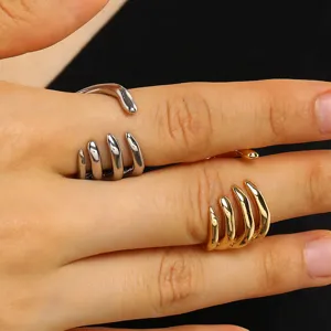 Macro view of punk style skeleton claw rings in gold and silver metallic finishes.